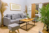 bing_rumah_modern_harga_segini_dapat_apa_perbandingan_fasilitas_vs_budget_2 Interior rumah modern dengan ruang tamu terbuka, sofa abu-abu, meja kayu, dan tanaman hias di sudut ruangan